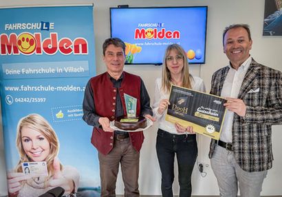 Fahrschule Molden Chef Ernst Molden und Bianca Dorfer vom Marketing freuten sich über den DooH Award, den monitorwerbung Kärnten Geschäftsführer Andreas Lanner übergab.